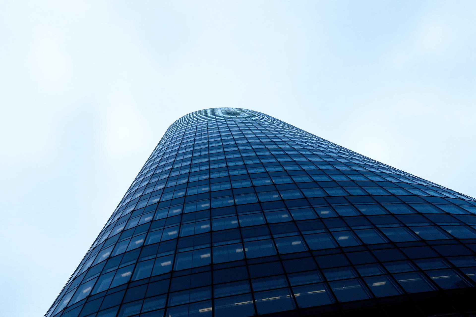 Modern glass tower rising into a blue sky
